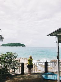 Rear view of woman looking at sea against sky
