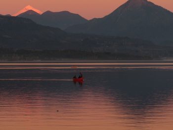 Scenic view of lake against mountains during sunset