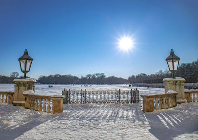 Built structure on snow covered street against blue sky