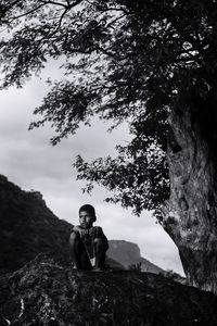 Portrait of young man sitting on rock