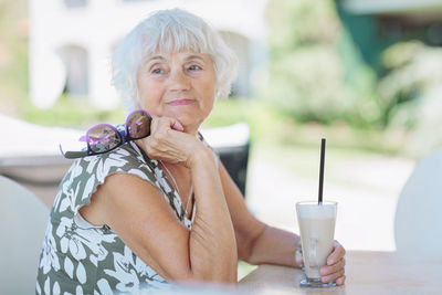 Beautiful senior woman with a cup of coffee with milk