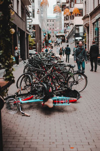 People riding bicycle on street against buildings in city