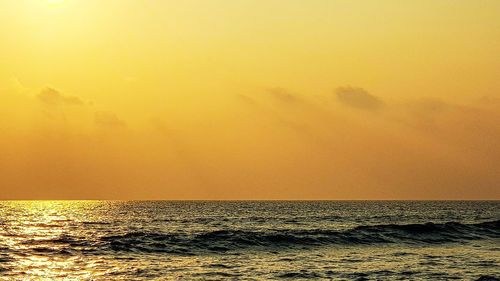 Scenic view of sea against orange sky