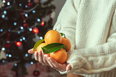 Close-up of hand holding orange fruit