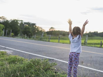 Rear view of woman walking on road