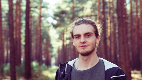 Portrait of young man standing in forest