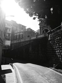 Empty road amidst buildings against sky