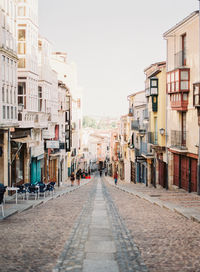 Street amidst buildings against sky in city