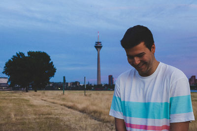 Man standing by tower against sky