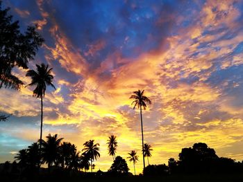 Low angle view of silhouette palm trees against sunset sky