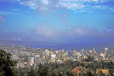 Cityscape by sea against sky