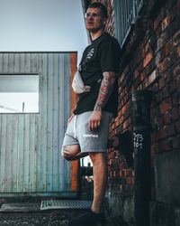 Portrait of young man standing against wall