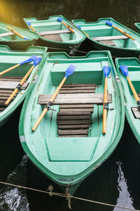 Green old empty boats with wooden oars on the lake closeup. recreational old row boats. boat rental