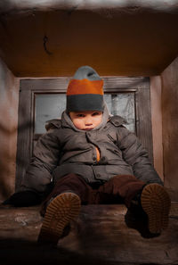 Portrait of boy sitting on sofa at home