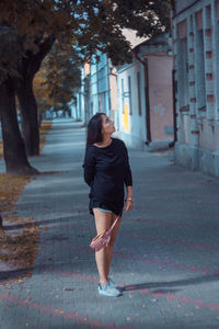 Full length of woman walking on footpath in city