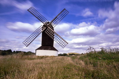 Traditional windmill on field against sky