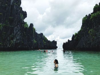 Man and woman standing on rock in water