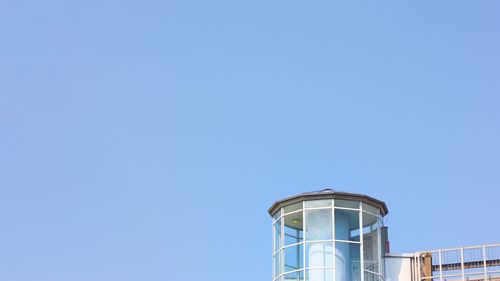 Low angle view of water tower against clear blue sky