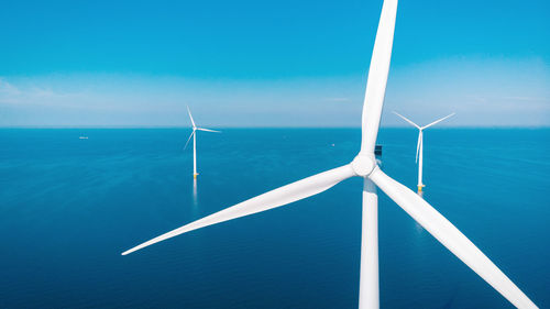 Low angle view of windmill against blue sky