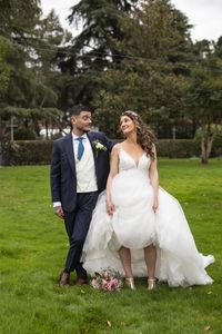 Bride and bridegroom standing on field