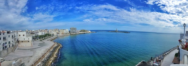Scenic shot of calm sea with cityscape in background