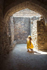 Rear view of woman standing in tunnel