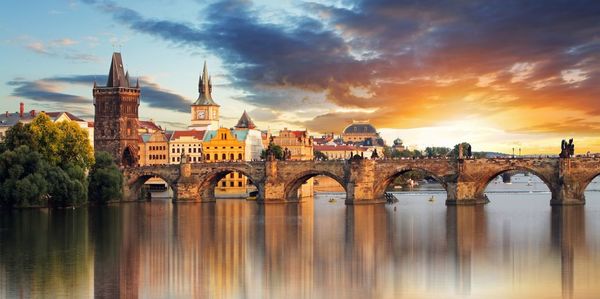 Arch bridge over river against buildings in city