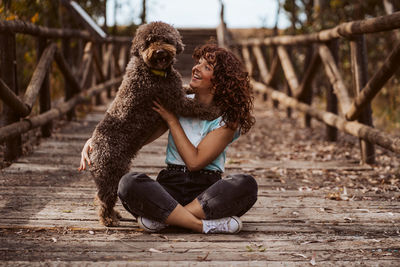 Low section of woman with dog on field