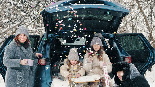 Winter tea picnic. happy family is having tasty snack, a tea party with cream, outdoors. 