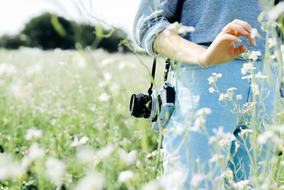 Close-up of hand holding flower on field