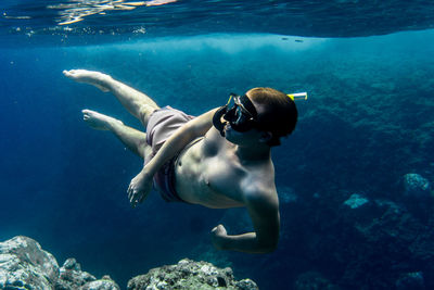 Shirtless young man snorkeling in sea