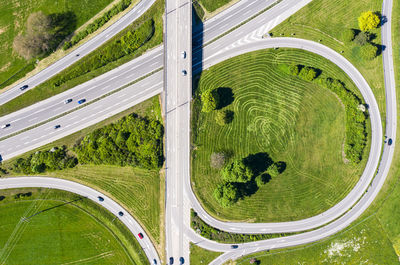 Aerial view of road amidst trees on field