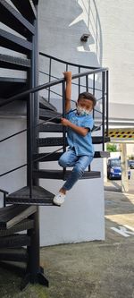 Boy on railing against built structure