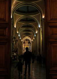 Silhouette people walking in corridor on church