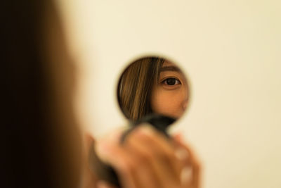 Reflection of woman's face in make-up mirror