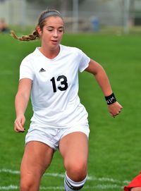 Portrait of teenage boy playing soccer on field