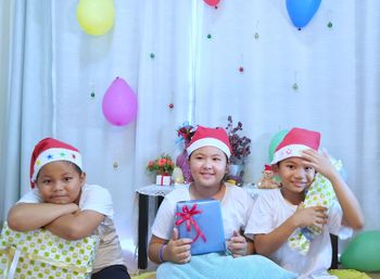 Portrait of happy siblings at home during christmas