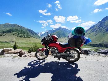 Rear view of man riding bicycle on mountain against sky