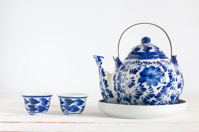 Close-up of tea cup on table against white background