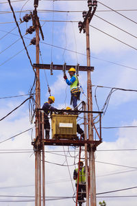 Low angle view of workers repairing cable