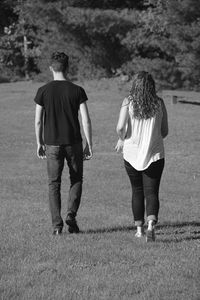 Rear view of friends walking on landscape