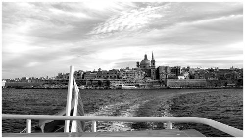 River by buildings against sky in city