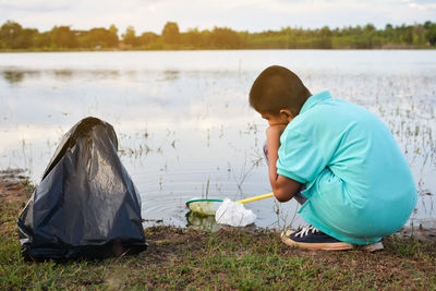 Boy with butterfly fishing net at lakeshore