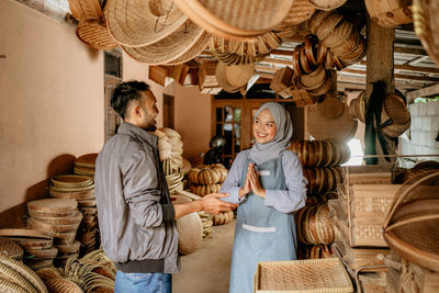 Side view of female friends working in store