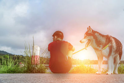 People with dog against sky