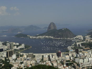 High angle view of townscape by sea against sky