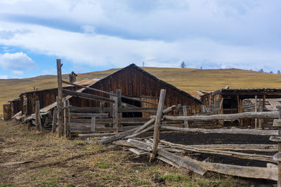 Old barn on field against sky