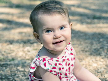 Close-up portrait of baby girl on field