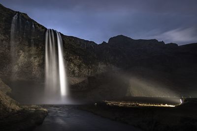 Scenic view of waterfall against sky