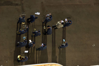 High angle view of men practicing music on footpath